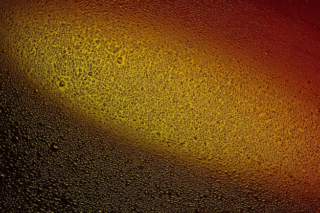 Water drops on black glass. Background illuminated with red and