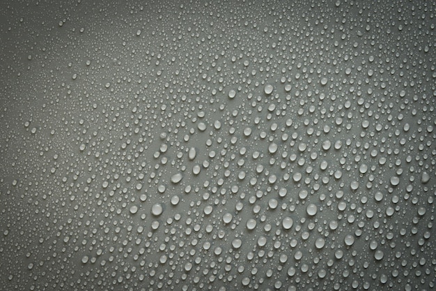 Water drops on a black plastic surface On a black background Top view