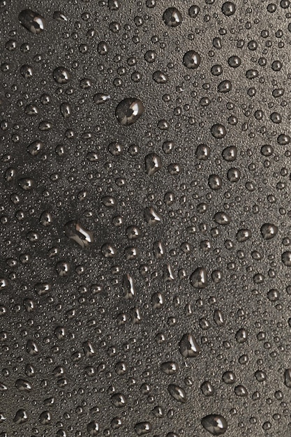 water drops on a black plastic surface. On a black background. Top view.