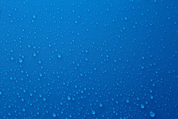 Water drops on blue background top view