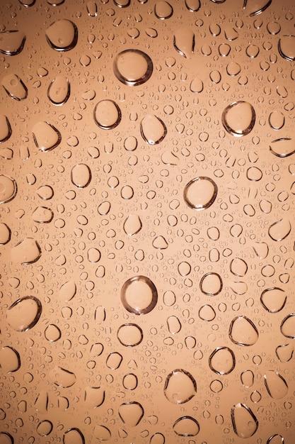 Water drops on Brown glass background.