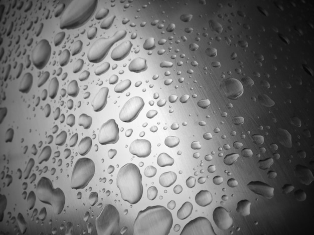 ぼんやりした背景でガラスの上に水滴が落ちる