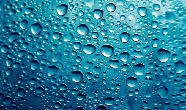 Water drops on glass as a background Condensation on a cold drink Blue background with drops texture