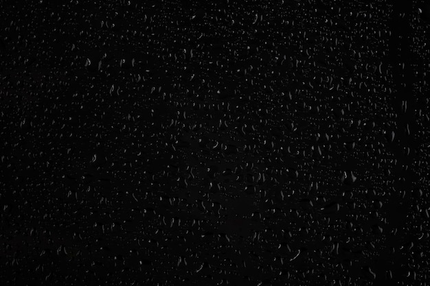 Water drops on glass on a black background