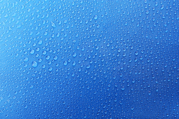 Water drops on glass on blue