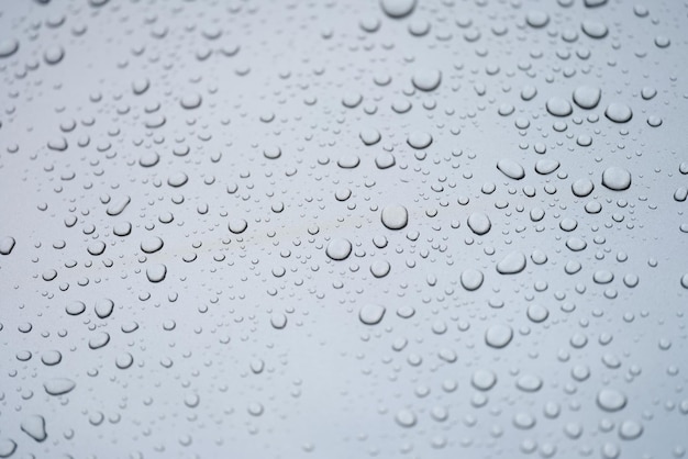 Water drops on glass gray background closeup