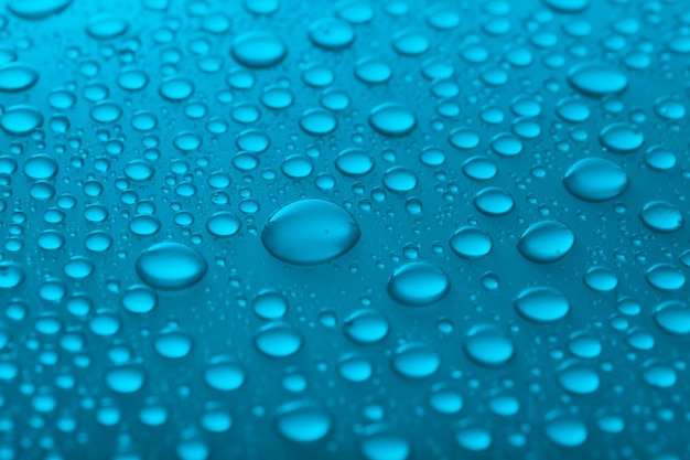 Water drops on glass on light background