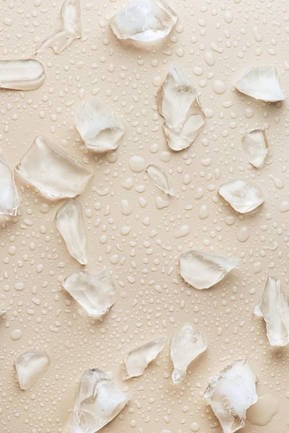 Water drops and ice on a beige background