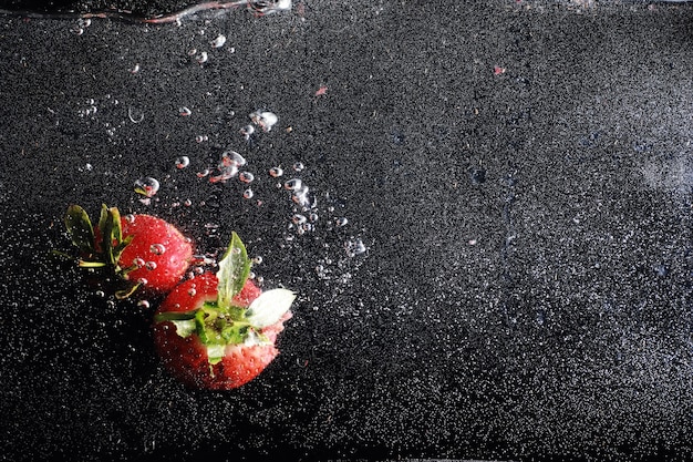 Фото Капли воды на спелой сладкой клубнике. свежие ягоды фон с копией пространства для вашего текста. концепция веганской еды.
