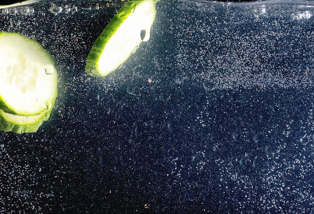 Water drops on ripe cucumber. Fresh vegetables background with copy space for your text. Vegan and vegetarian concept.