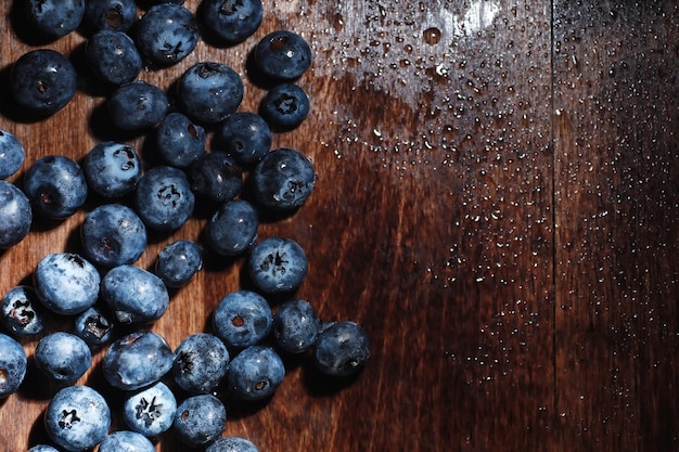 Water drops on ripe sweet blueberry. Fresh blueberries background with copy space for your text. Vegan and vegetarian concept. Macro texture of blueberry berries.Texture blueberry berries close up