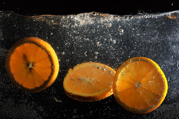 熟した甘いオレンジに水が落ちる。あなたのテキストのためのコピースペースと新鮮なマンダリンの背景。ビーガンとベジタリアンの概念。