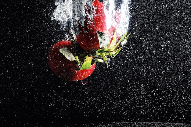 Water drops on ripe sweet strawberry. Fresh berry background with copy space for your text. Vegan food concept.