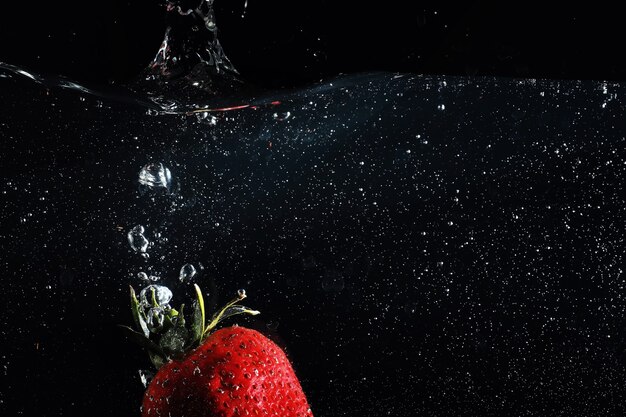 Water drops on ripe sweet strawberry. Fresh berry background with copy space for your text. Vegan food concept.