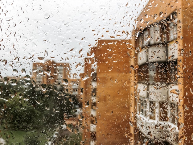 雨の日、窓ガラスに水滴が落ちる