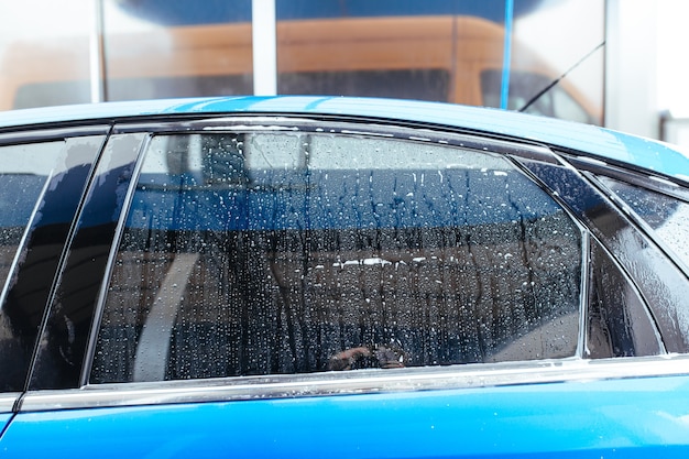 Капли воды на лобовом стекле автомобиля. концепция автомойки