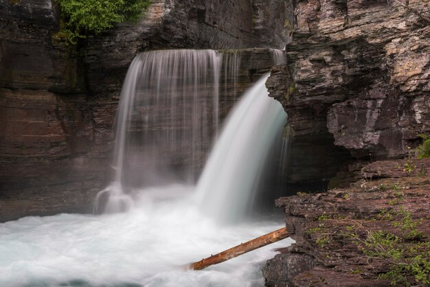 Water falling from rocks in a forest, st mary falls, glacier\
national park, glacier county, montana,