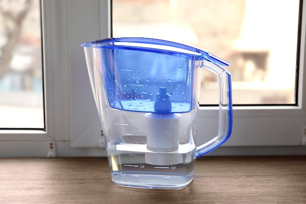 Water filter jug on the wooden windowsill