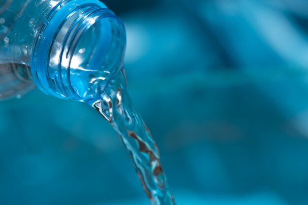 Foto acqua che scorre da una bottiglia acqua che si versa nel bicchiere versare acqua dalla bottiglia nel bicchiere