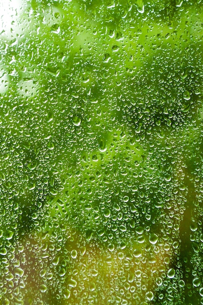 Water flows down the glass, behind blurred background