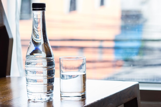 Water glass and bottle on wooden background