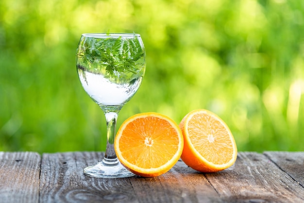 水ガラスと自然の中でオレンジをカットします。