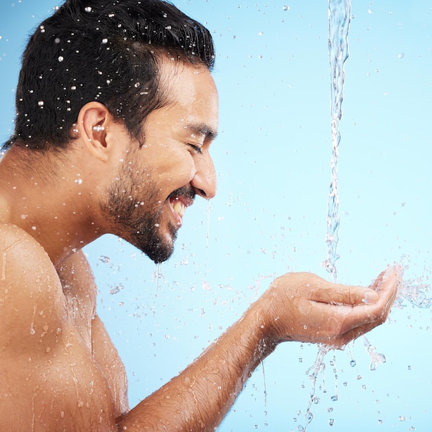 Water hands or man in shower in studio cleaning body for wellness or skincare with a happy smile Water splash mock up or relaxed model washing for self care grooming with marketing or mockup space