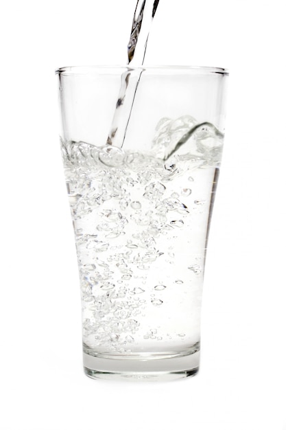 Water in glas dat op witte achtergrond wordt geïsoleerd
