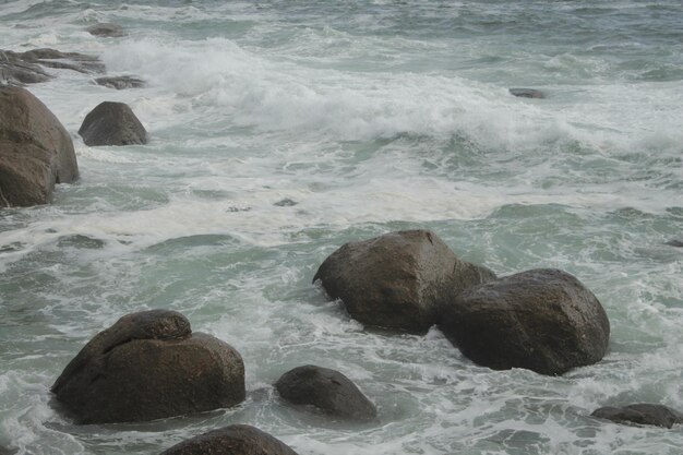 Photo the water is choppy and has a wave crashing on it