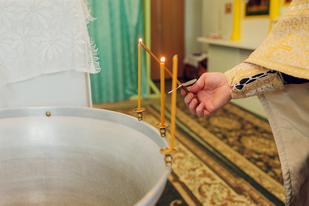 L'acqua viene versata nella fonte per fare il bagno al bambino nella chiesa, tradizioni religiose.