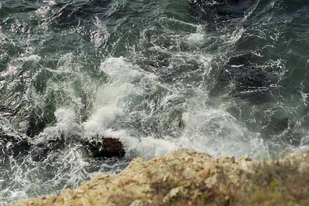 Water klopt op de steen in de schuimende golven zee