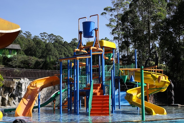 Water park bright multicolored slides with a pool a water park\
without people on a summer day