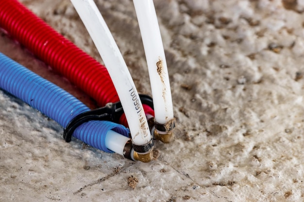 Water pipes corrugated in red and blue. plumbing system in the floor. pipe laying on the floor of the house.