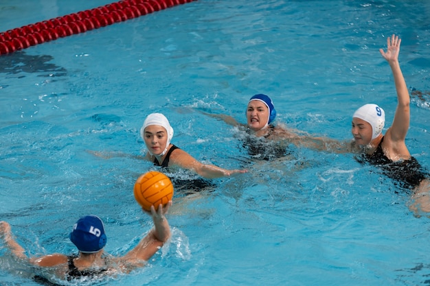 Foto giocatori di pallanuoto in piscina con attrezzatura per il nuoto