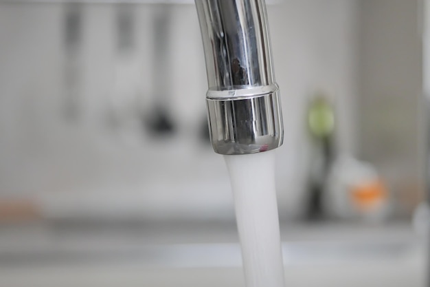 Water pouring from a faucet tap slow motion