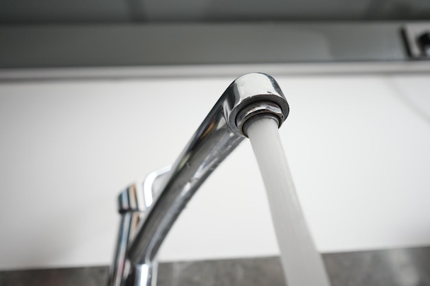 Water pouring from a faucet tap slow motion