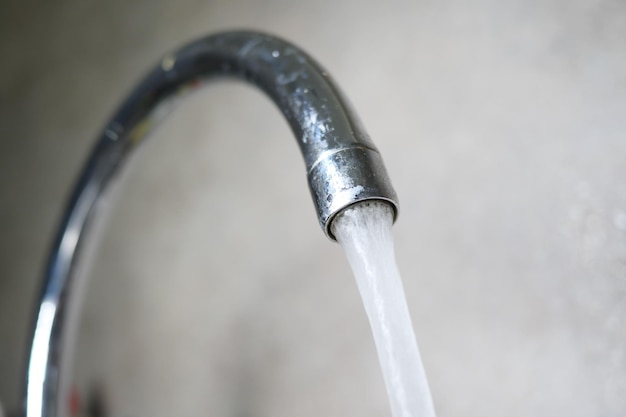 Water pouring from a faucet tap slow motion