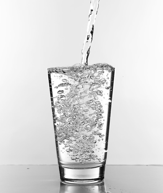 Photo water pouring in glass isolated on white