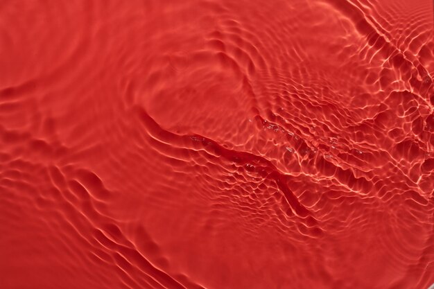 Water red surface abstract background Waves and ripples texture of cosmetic aqua moisturizer with bubbles