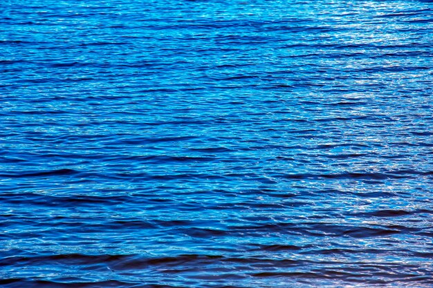 Photo water ripple texture background wavy water surface during sunset golden light reflecting in the water