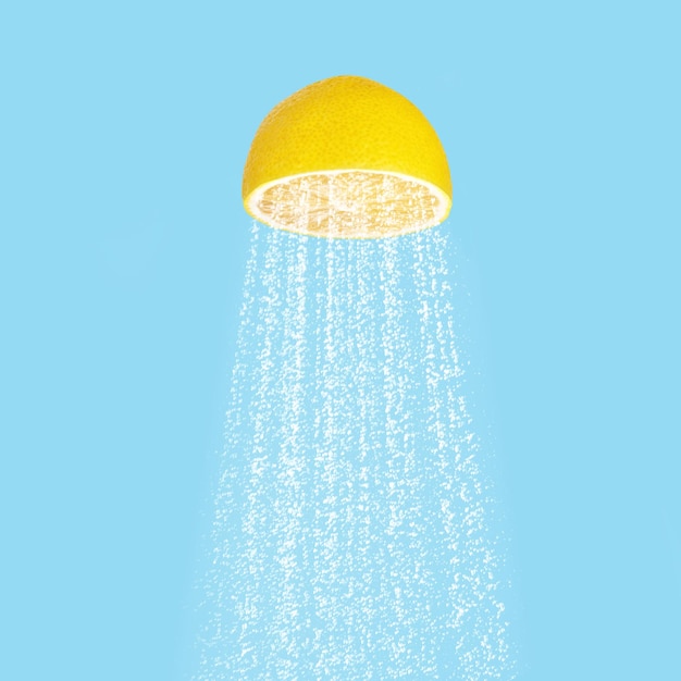 Foto acqua che scorre da fette di limone come soffione doccia in studio con sfondo blu. concetto estivo.