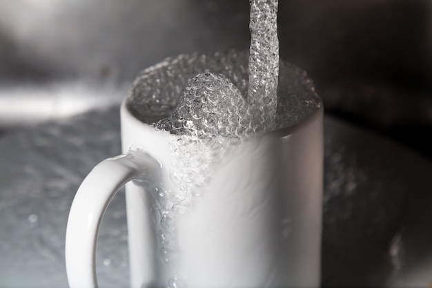 Foto acqua corrente. spreco di acqua potabile con il rubinetto aperto