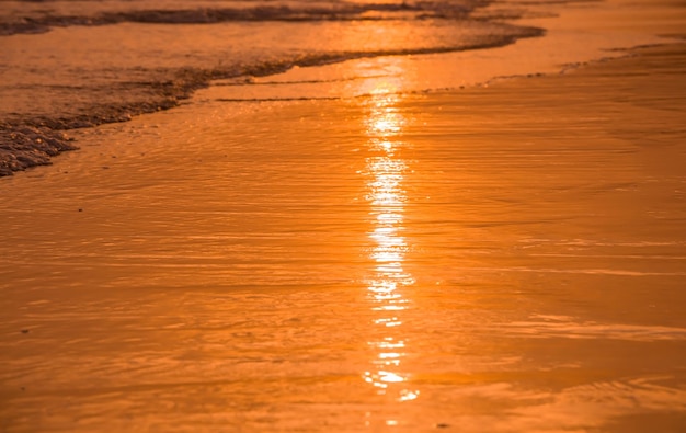 Вода и песок на пляже во время заката