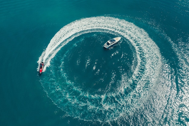 Water scooter movement close to the yacht aerial view