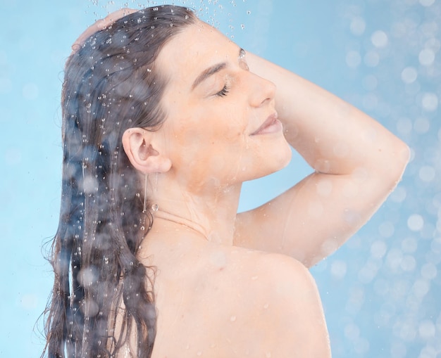 Photo water shower and woman cleaning body on blue background of healthy skincare beauty or wellness young studio model water drops and personal hygiene bathroom and cosmetics self care or fresh face