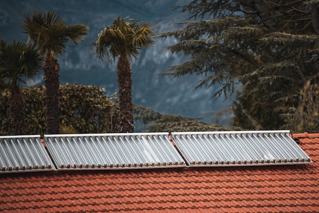 Water solar collector on a red metal roof Solar thermal and solar panel for hot water