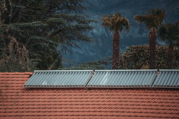 Water solar collector on a red metal roof Solar thermal and solar panel for hot water