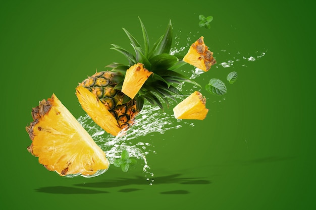 Water spatten op verse ananas is tropisch fruit geïsoleerd op groen