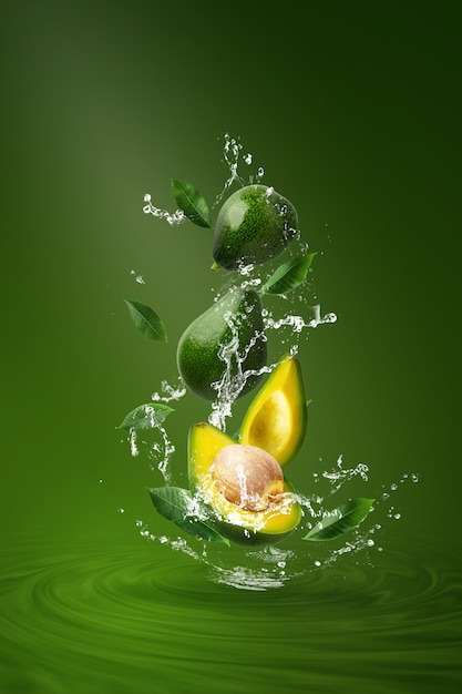 Water spatten op verse gesneden groene avocado over groen.