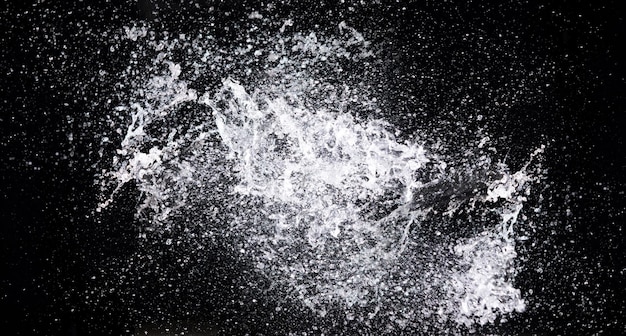 Water splash in air drop over black background studio lighting high speed